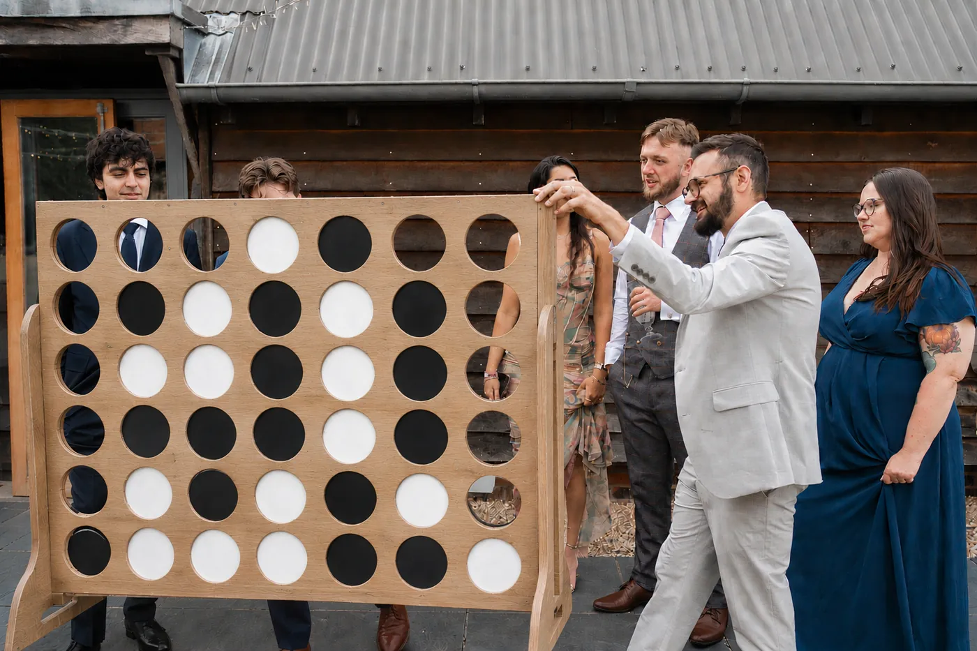 Wedding guests playing giant Connect 4 garden game