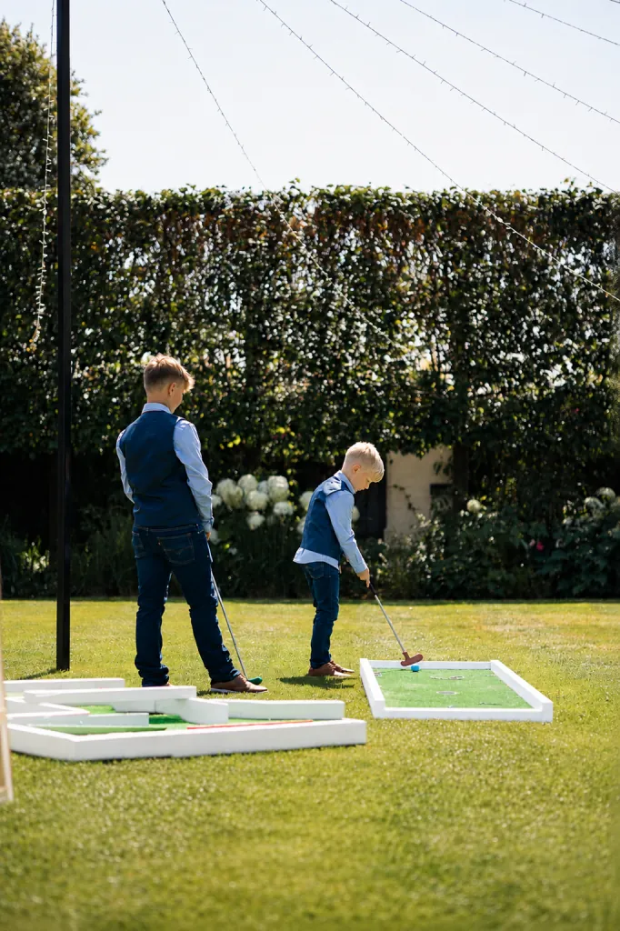 Children playing the mini golf course at a wedding